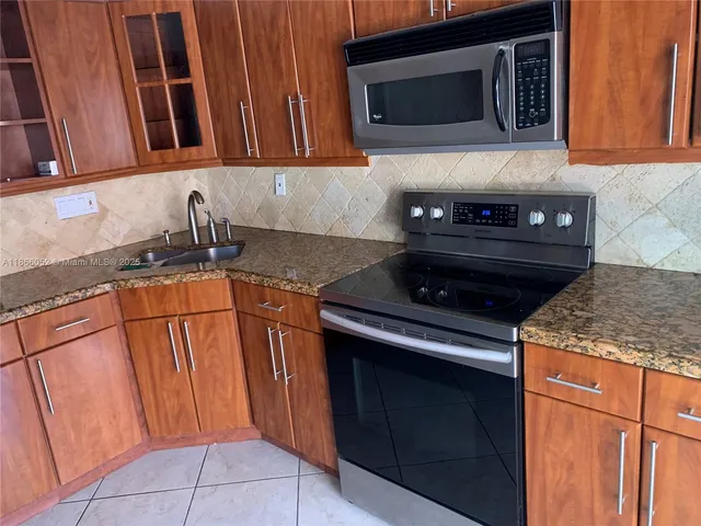 a kitchen with stainless steel appliances granite countertop a stove microwave and sink