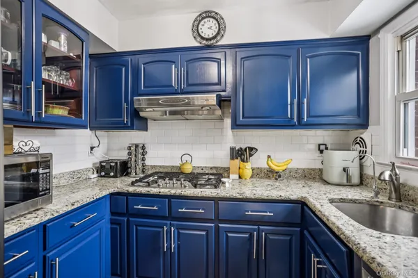 a kitchen with a sink a stove and cabinets