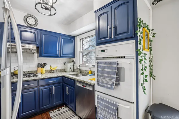 a kitchen with a sink a stove cabinets and wooden floor