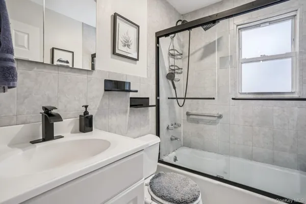 a bathroom with a sink a toilet and mirror