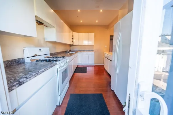 a kitchen with stainless steel appliances granite countertop a refrigerator and a stove