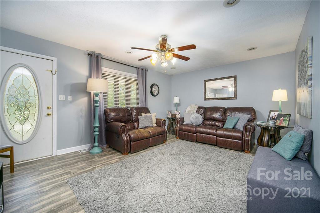 833 Long Branch Road Grover, NC 28073 - Photo 12 of 29 a living room with furniture a clock potted plant and a ceiling fan