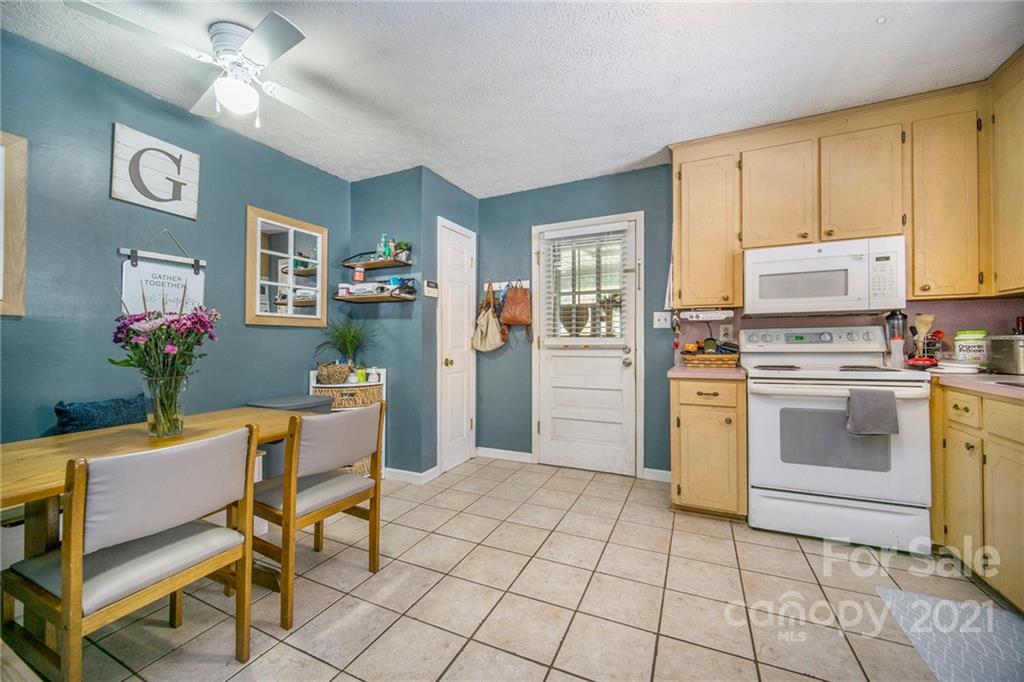833 Long Branch Road Grover, NC 28073 - Photo 5 of 29 a kitchen with a stove a chimney a dining table and chairs