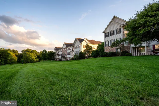 a view of a house with a big yard and large trees