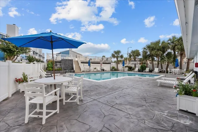a view of a patio with a table and chairs under an umbrella