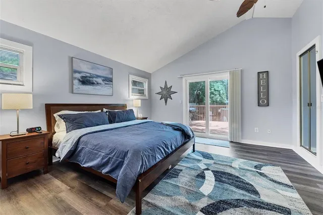 a spacious bedroom with a bed lamp on desk and a window