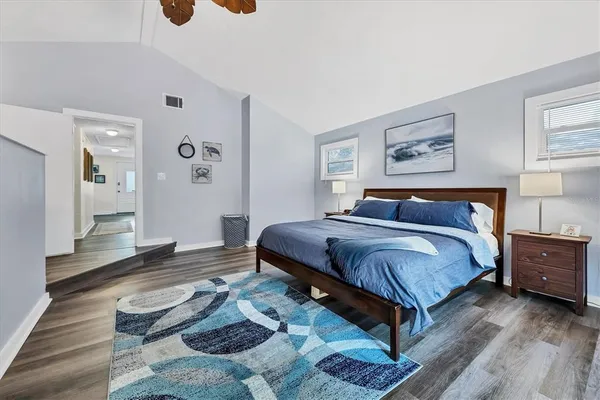 a bedroom with a bed and wooden floor