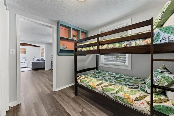 a bedroom with a bed and wooden floor
