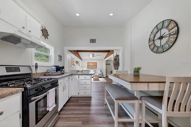 a kitchen with a table chairs stove and cabinets