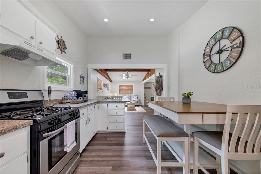 900 Beverly Avenue Northwest Largo, FL 33770 - Photo 9 of 32 a kitchen with a table chairs stove and cabinets
