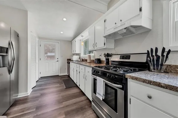 a kitchen with stainless steel appliances granite countertop a stove and a refrigerator