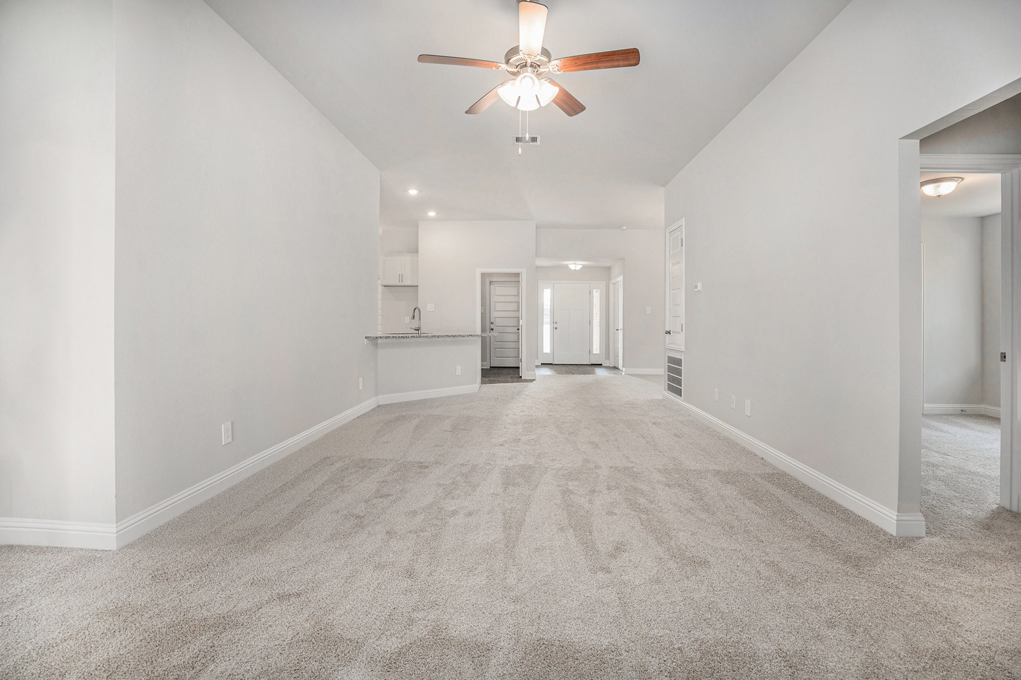 408 Bryan Street Angleton, TX 77515 - Photo 2 of 17 an empty room with a ceiling fan and a window