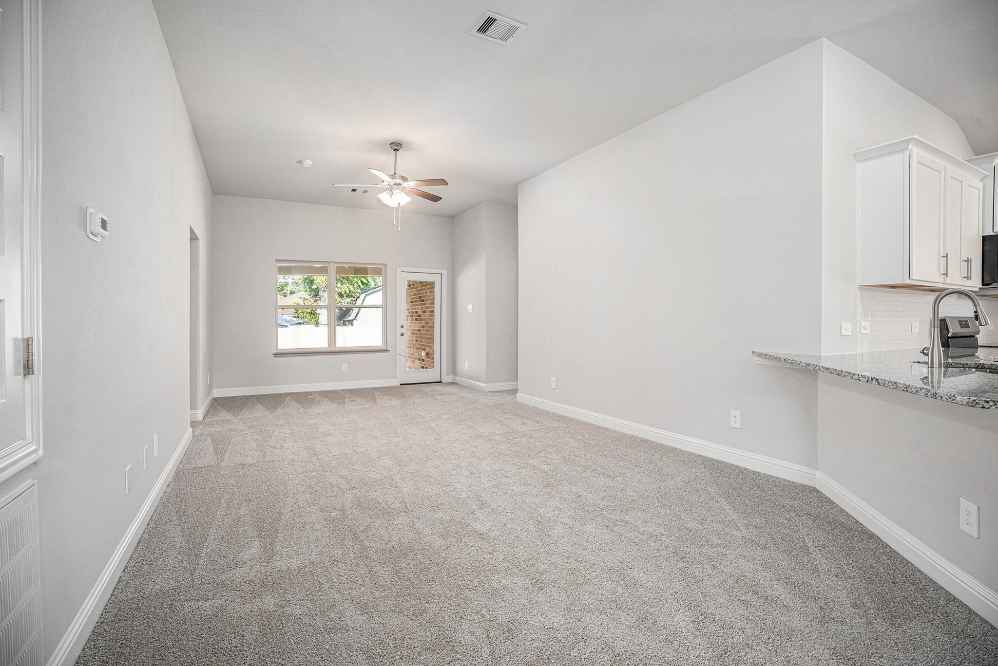 408 Bryan Street Angleton, TX 77515 - Photo 3 of 17 an empty room with windows and chandelier fan