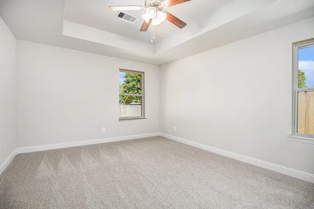 an empty room with a window and a fan