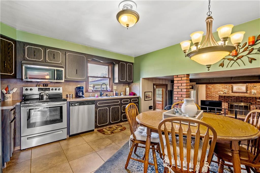 279 Hamtom Road Eighty Four, PA 15330 - Photo 9 of 25 a kitchen with stainless steel appliances granite countertop a stove a sink dishwasher a dining table and chairs with wooden floor