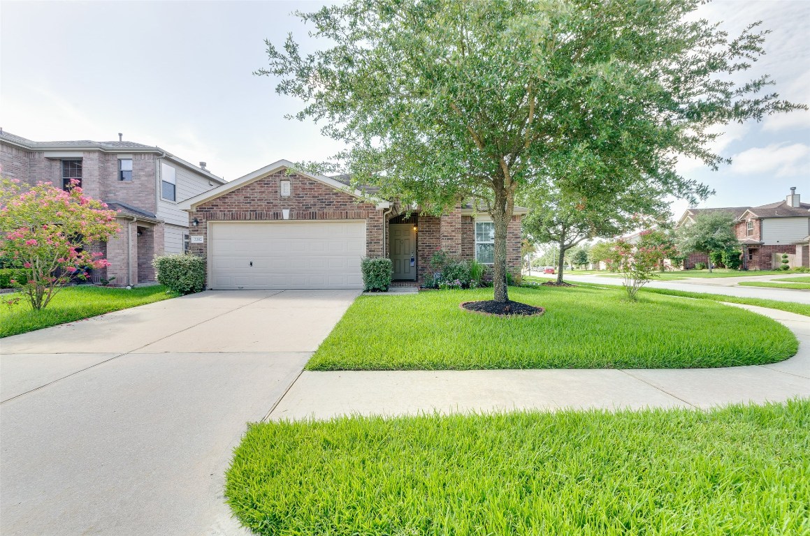 3302 Legends Landing Drive Spring, TX 77386 - Photo 5 of 48 a front view of a house with a garden and trees