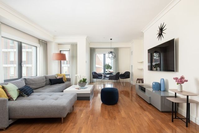 a living room with furniture a flat screen tv and a large window