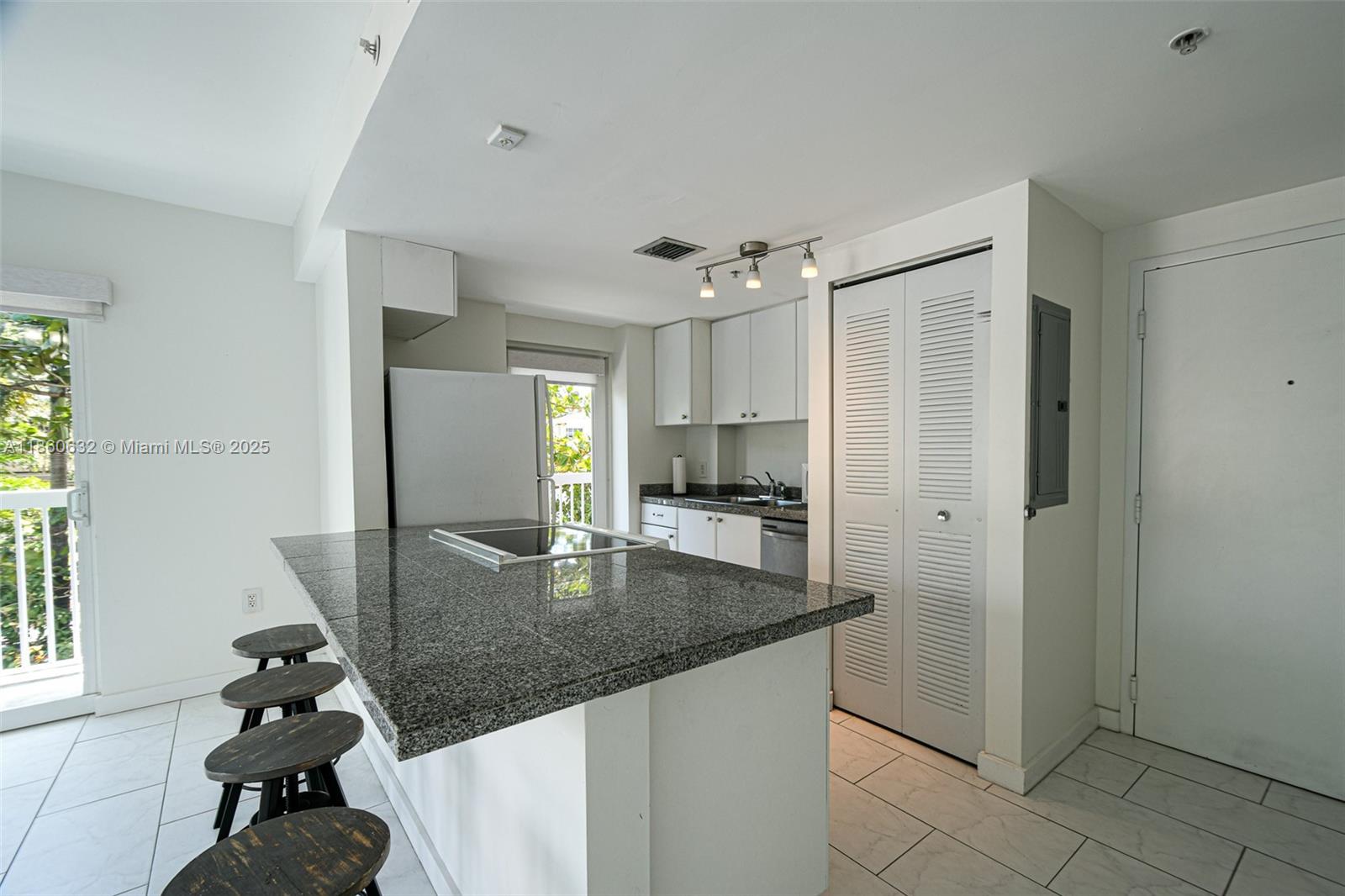 2740 Southwest 28th Terrace, Unit 201 Miami, FL 33133 - Photo 3 of 15 a kitchen with stainless steel appliances granite countertop a sink refrigerator and stove