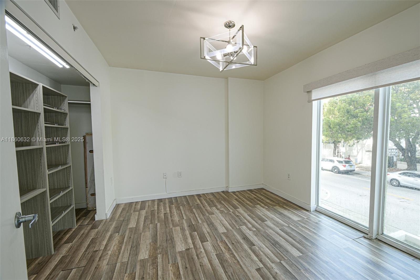 2740 Southwest 28th Terrace, Unit 201 Miami, FL 33133 - Photo 7 of 15 wooden floor in an empty room with a window