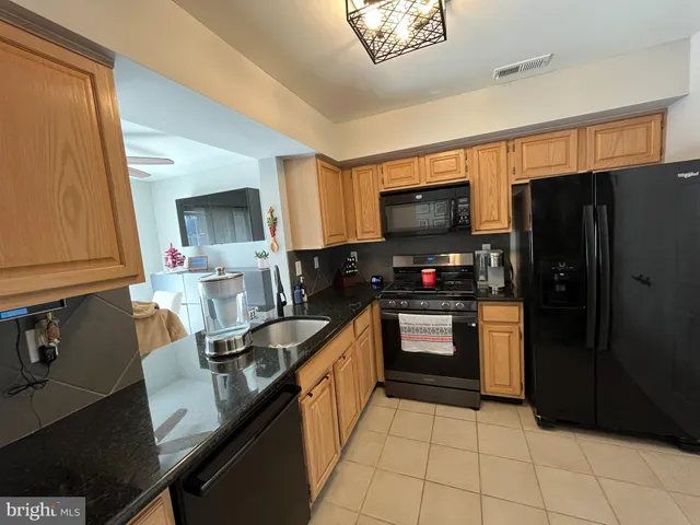a kitchen with granite countertop a refrigerator and a sink