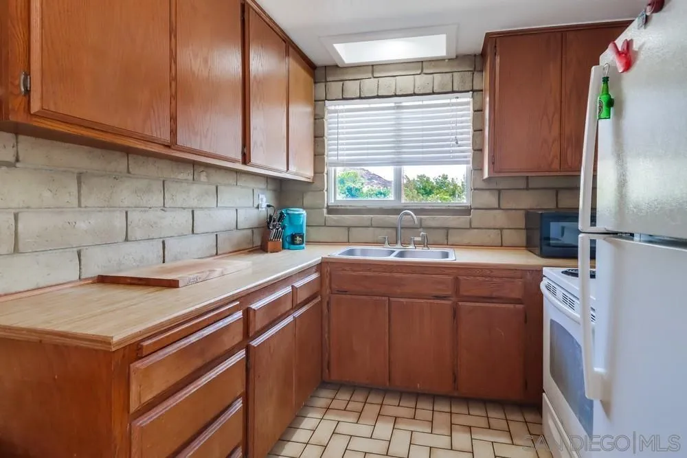 12718 Willow Road Lakeside, CA 92040 - Photo 26 of 46 a kitchen with a sink stove and cabinets