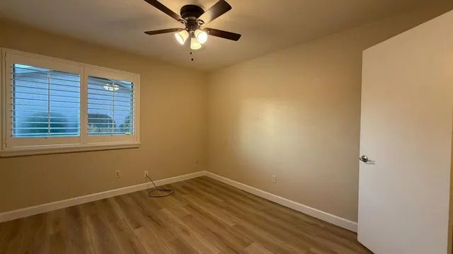 an empty room with a window and wooden floor