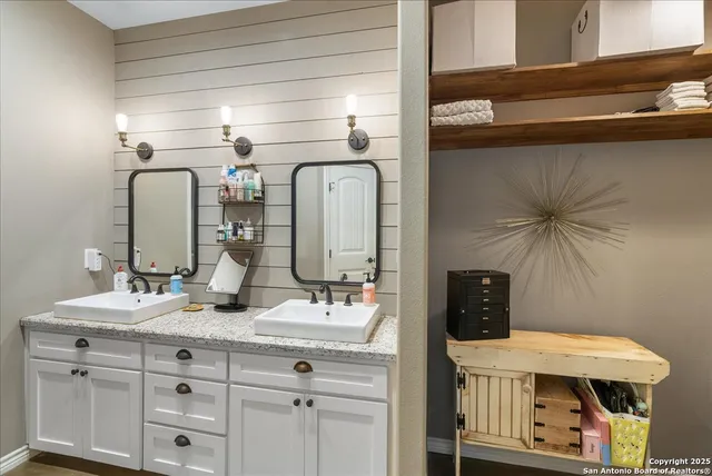 a bathroom with a double vanity sink and a mirror