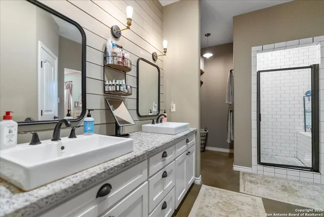 a bathroom with double vanity and a mirror