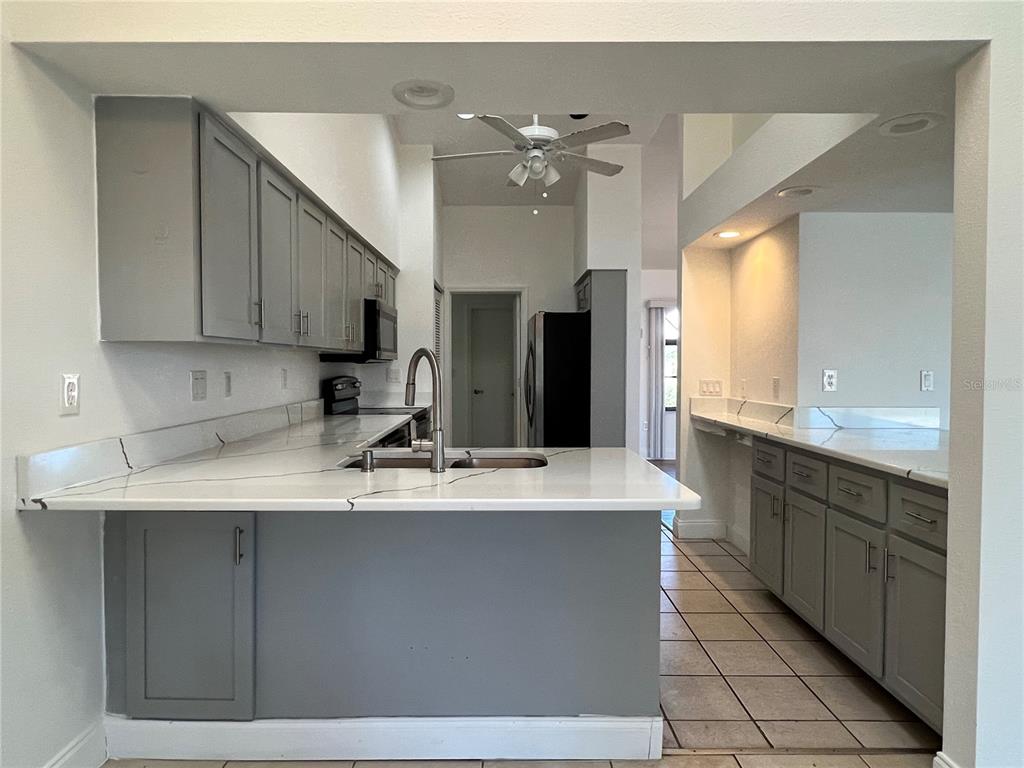 2092 Rio De Janeiro Avenue Punta Gorda, FL 33983 - Photo 11 of 50 a large kitchen with kitchen island granite countertop a sink window and cabinets