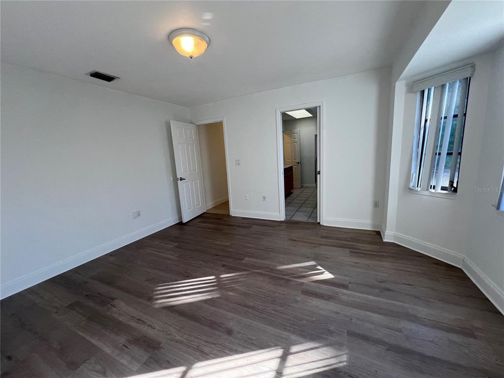 2092 Rio De Janeiro Avenue Punta Gorda, FL 33983 - Photo 26 of 50 an empty room with wooden floor and mirror