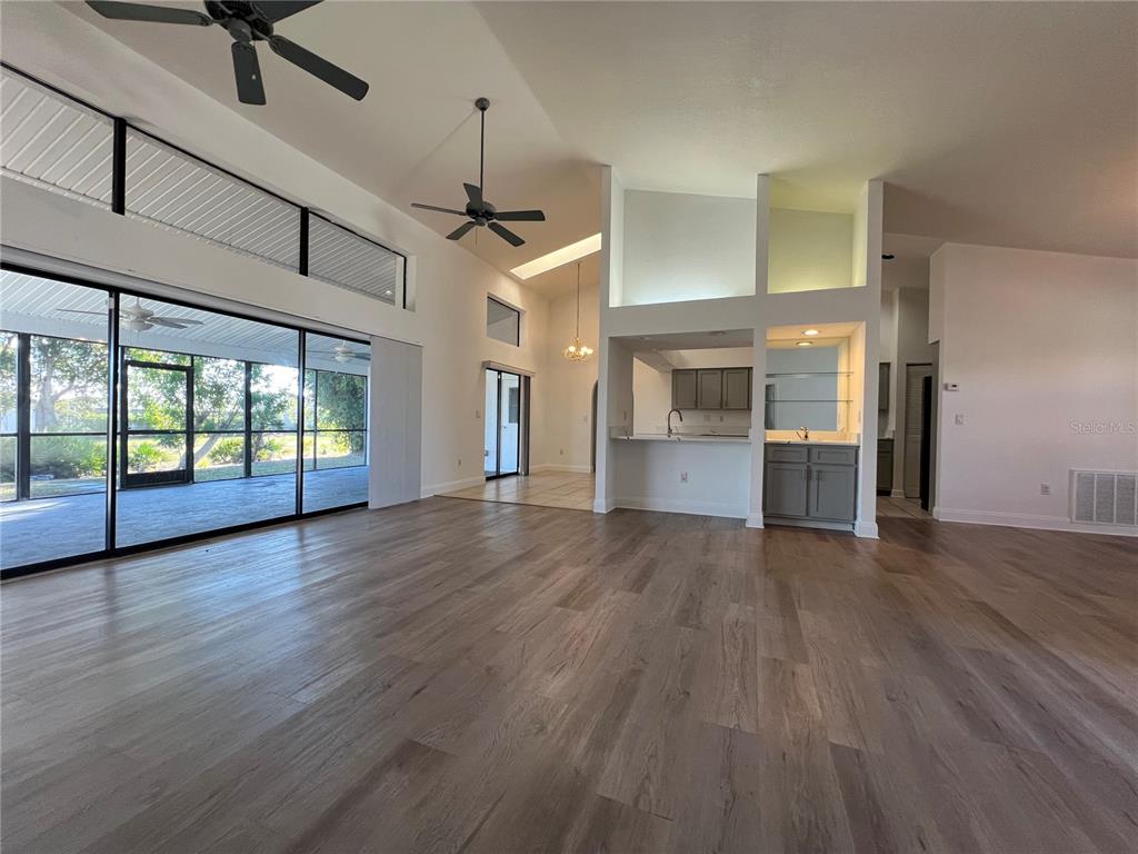 2092 Rio De Janeiro Avenue Punta Gorda, FL 33983 - Photo 4 of 50 an empty room with wooden floor fireplace and windows