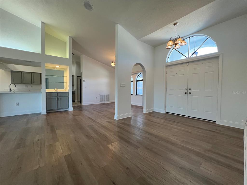 2092 Rio De Janeiro Avenue Punta Gorda, FL 33983 - Photo 5 of 50 an empty room with wooden floor mirror and windows
