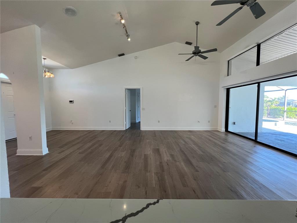 2092 Rio De Janeiro Avenue Punta Gorda, FL 33983 - Photo 6 of 50 an empty room with wooden floor a ceiling fan and windows