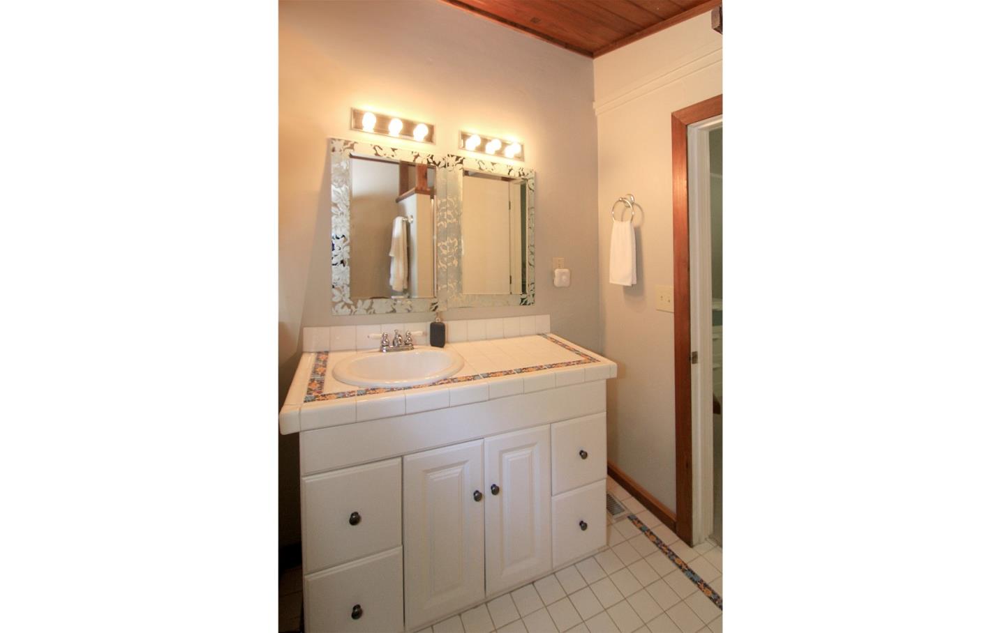 10990 Riverside Road Brookdale, CA 95005 - Photo 25 of 29 a bathroom with a double vanity sink and mirror