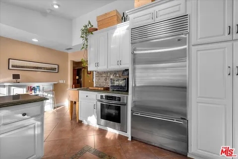 a kitchen with a refrigerator stove and white cabinets