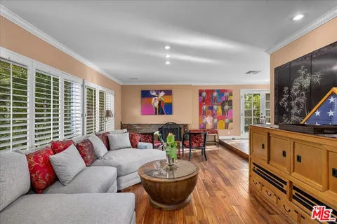 a living room with furniture a flat screen tv and a large window