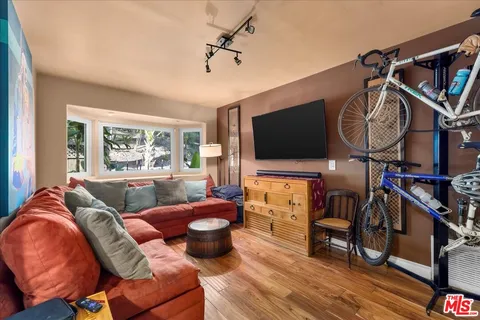 a living room with furniture a flat screen tv and a large window