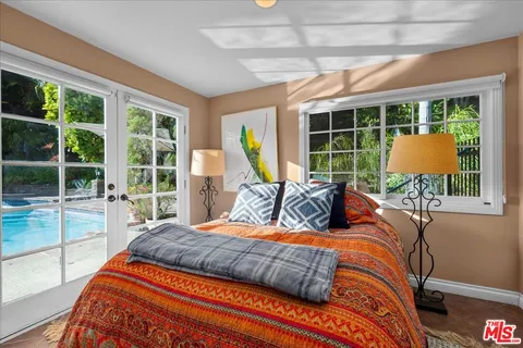 a bedroom with bed and glass windows