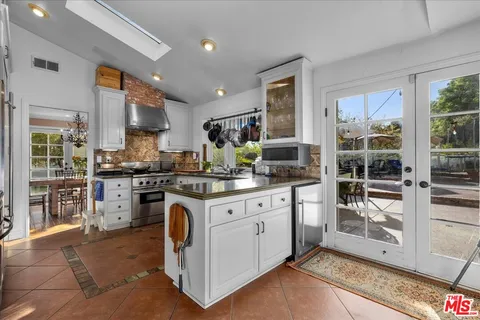 a kitchen with stainless steel appliances granite countertop a stove a sink and a refrigerator