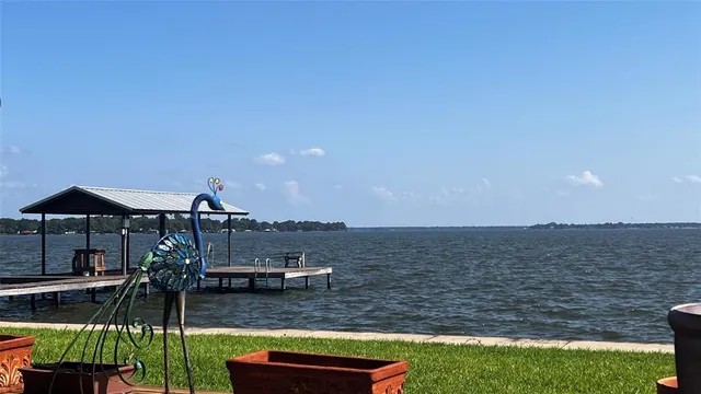 a view of a lake with a big yard and potted plants