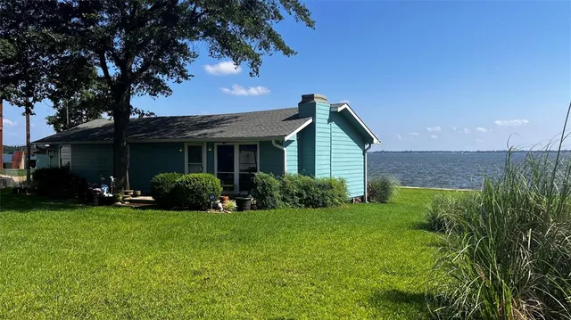 a view of a house with a yard and potted plants
