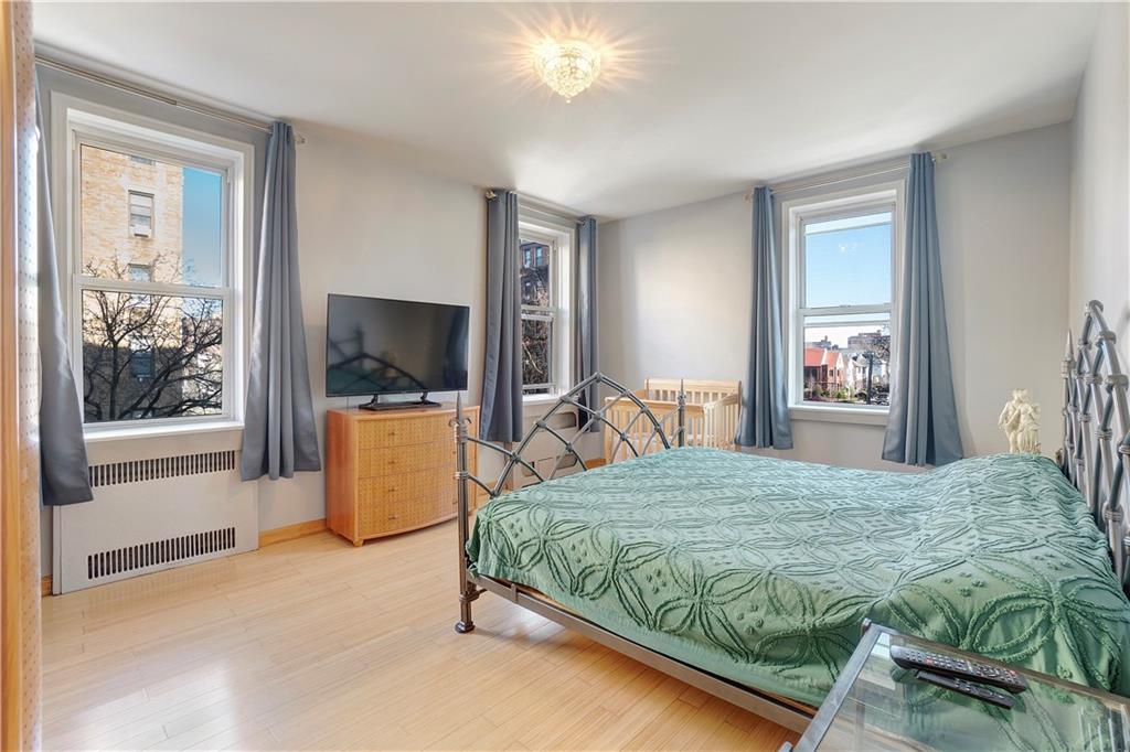 1900 Quentin Road, Unit C4 Brooklyn, NY 11229 - Photo 8 of 13 a bedroom with a large bed and a flat tv screen on dresser