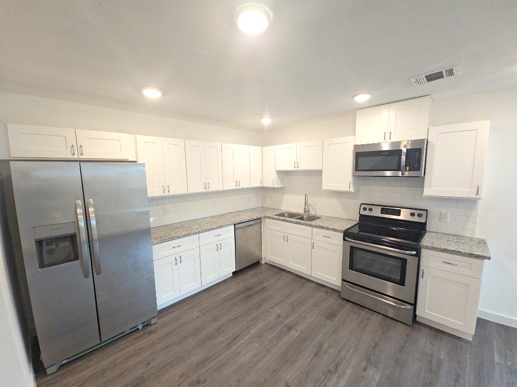 6315 Sandra Street, Unit A Houston, TX 77028 - Photo 13 of 21 a kitchen with stainless steel appliances and wooden floor