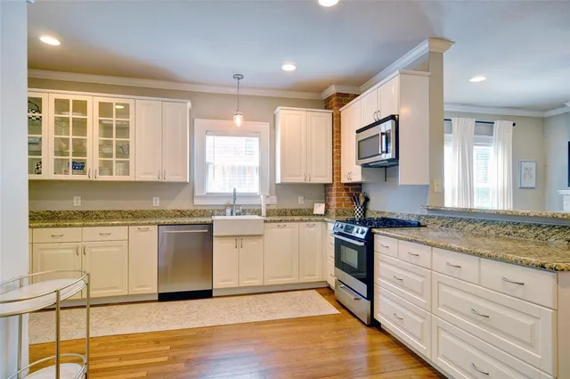 a kitchen with stainless steel appliances kitchen island granite countertop a stove and a sink