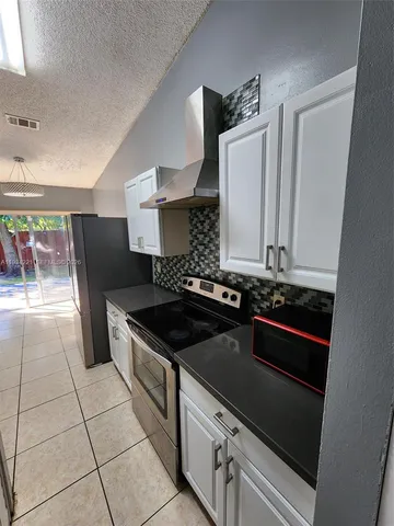 a kitchen with granite countertop a stove and a refrigerator