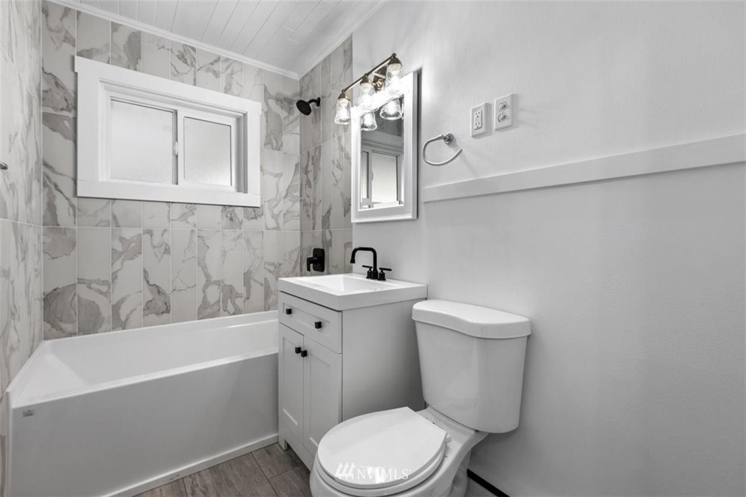 2613 Northeast 6th Place Renton, WA 98056 - Photo 12 of 27 a bathroom with a sink a mirror a toilet and bathtub