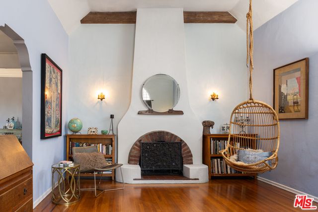 a living room with furniture a fireplace and wooden floor