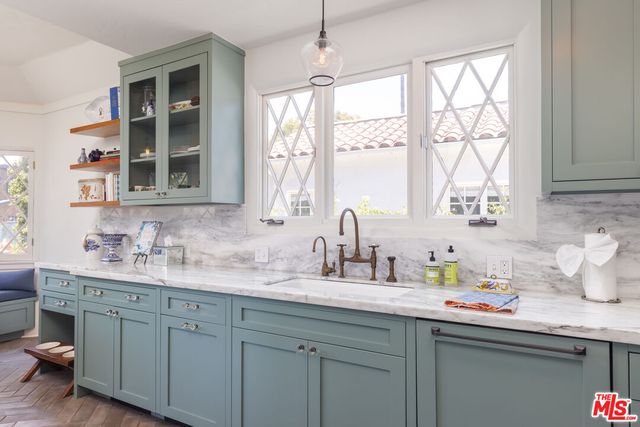 a kitchen with stainless steel appliances white cabinets a sink and a window