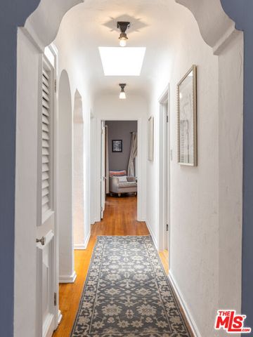 a hallway with wooden floor windows and entryway