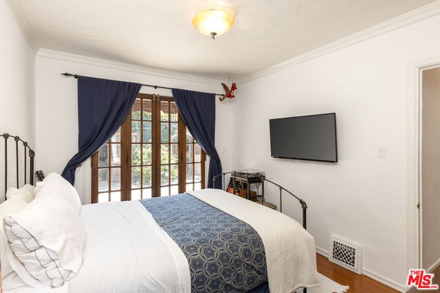 a bedroom with a bed and a flat screen tv